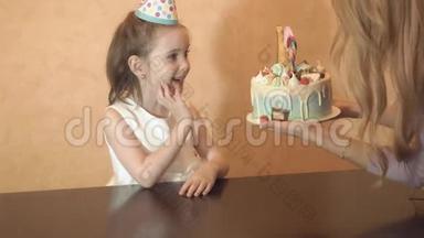 孩子们`生日聚会。 给小生日女孩的生日蛋糕。 家庭庆祝活动